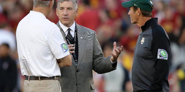 FILE- In this Sept. 27, 2014, file photo, Big 12 Conference Commissioner Bob Bowlsby, center, talks with Iowa State coach Paul Rhoads, left, and Baylor coach Art Briles before an NCAA college football game in Ames, Iowa. The Big 12 has publicly reprimanded and fined Iowa State athletic director Jamie Pollard $25,000 for his rant against league officiating. (AP Photo/Charlie Neibergall)
