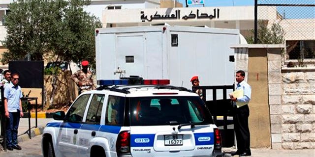 July 28: A prison van carrying Sheik Abu-Mohammed al-Maqdisi is escorted by police vehicles to a military court in Amman, Jordan.