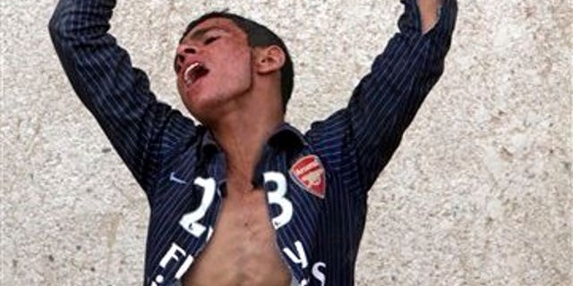 June 6: Ali Majeed, 16, reacts during the funeral for his father, Mohammed, 50, in the Shiite holy city of Najaf 160 kilometers (100 miles) south of Baghdad, Iraq. Mohammed was killed when a car bomb exploded outside a Baghdad police station Sunday in the deadliest of a pair of attacks that killed six people, police said.
