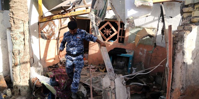 Sept. 19, 2014 - An Iraqi federal policeman inspects the site of the aftermath of a car bomb attack the northern Shiite district of Kazimiyah, in Baghdad, Iraq. A series of bomb & mortar shell attacks in and around Baghdad killed 20, Iraqi officials said.