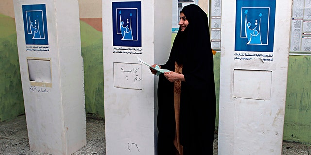 An Iraqi woman prepares to casts her vote in the country's parliamentary elections in Basra.