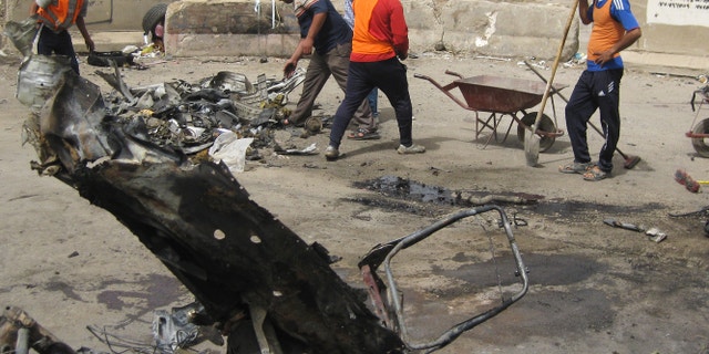 April 19, 2012: Baghdad municipality workers clean up after a car bomb attack in Palestine Street, Baghdad.