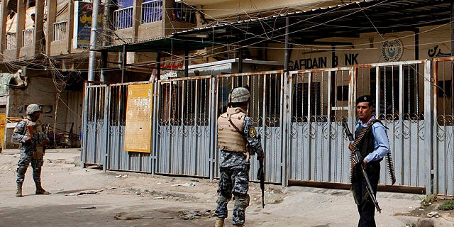 Sept. 30, 2010: Iraqi policemen stand guard outside the branch of the state-run al-Rafidain bank in southwestern Baghdad, Iraq.