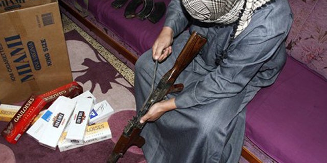 Feb. 14, 2012: Iraqi smuggler Younis al-Lehaibi, 46, dismantles an AK-47 machine-gun at his house.