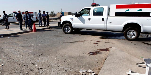 Oct. 27, 2010: Iraqi security forces inspect the scene of a roadside bomb, which exploded in northern Baghdad, Iraq, Wednesday. Iraqi police say a bombing at a checkpoint near the headquarters of a Sunni foundation in north Baghdad has killed security guards.