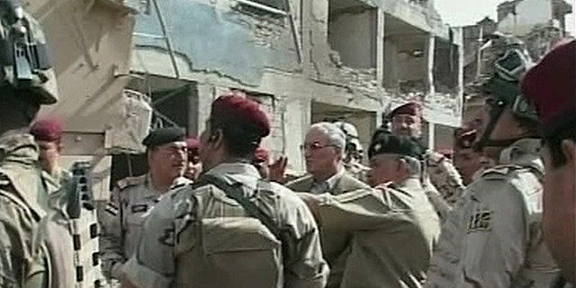 In this image made from television, Iraqi Defense Minister Abdul-Qadir al-Ubaidi , center, inspects the site of a suicide attack accompanied by soldiers at a military headquarters in Baghdad, Sunday, Sept. 5, 2010. Suicide bombers hit a Baghdad military headquarters on Sunday and killed dozens of people, two weeks after an attack on the same site pointed to the failure of Iraqi forces to plug even the most obvious holes in their security. (AP Photo/APTN)