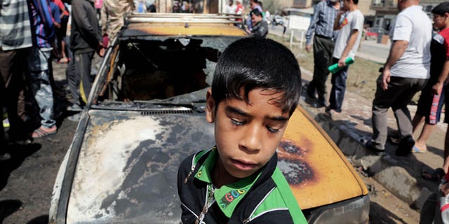 April 9, 2014: Civilians inspect the site of a car bomb attack in Baghdad's Sadr City neighborhood, Iraq.