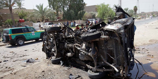 Aug. 15, 2013: Civilians inspect the aftermath of a car bomb attack in Baghdad, Iraq.