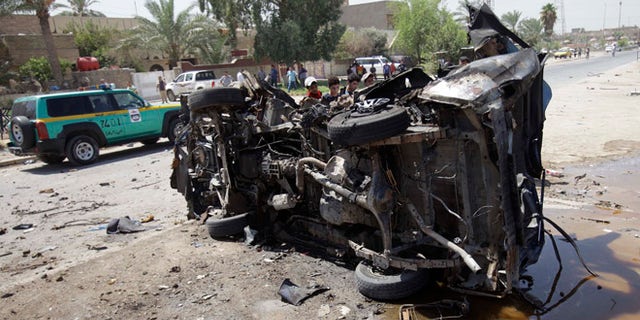 Aug. 15, 2013: Civilians inspect the aftermath of a car bomb attack in Baghdad, Iraq.