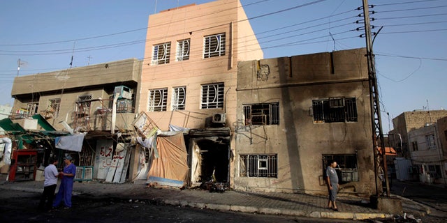 July 21, 2013: Civilians inspect the aftermath of a car bomb attack in the neighborhood of Tobjee in Baghdad, Iraq.