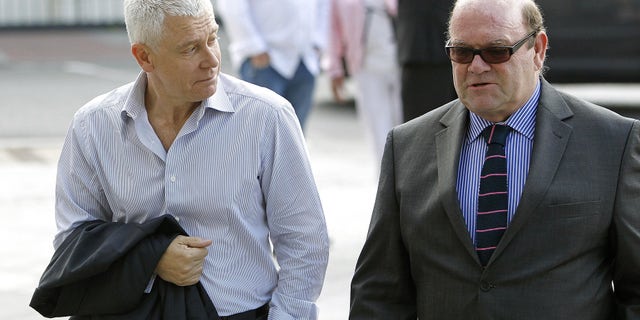 U2 bass guitarist Adam Clayton (left) arrive swith U2 manager Paul McGuinness at Dublin Circuit Criminal Court, where his former personal assistant, Carol Hawkins, is on trial for more then 184 counts relating to the alleged embezzlement of 2.8 million euro ($3.56 million) of his funds Wednesday June 20, 2012. (AP Photo/Julien Behal/PA) UNITED KINGDOM OUT NO SALES NO ARCHIVE