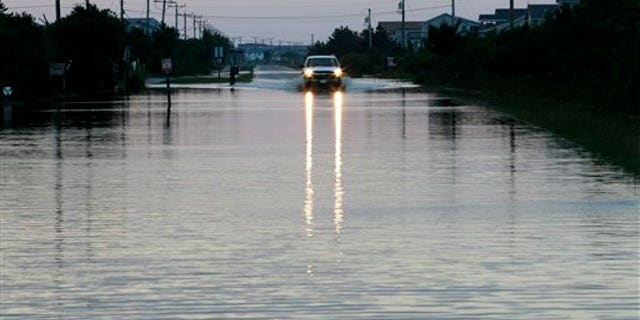 Aug. 28: A vehicle navigates through water in the road left behind by Hurricane Irene in Nags Head, N.C. The hurricane unloaded more than a foot of water on North Carolina, spun off tornadoes in Virginia, Maryland and Delaware, and left 3 million homes and businesses without power as it moved up the East Coast.