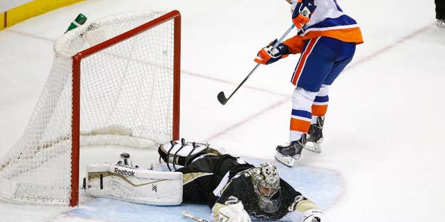 New York Islanders' Kyle Okposo (21) gets a game-winning shot past Pittsburgh Penguins goalie Marc-Andre Fleury (29) during a shootout of an NHL hockey game in Pittsburgh Friday, Nov. 21, 2014. The Islanders won 5-4. (AP Photo/Gene J. Puskar)