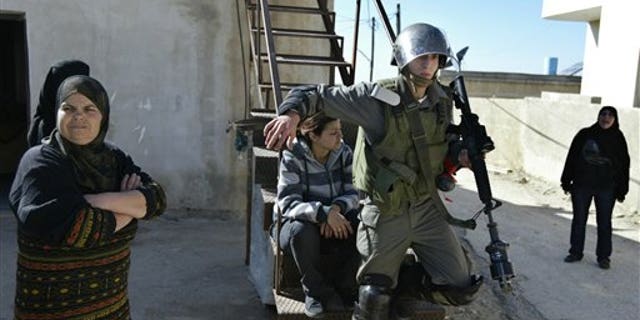 Feb. 18, 2011: An Israeli border police officer walks out from a Palestinian house during clashes with Palestinian demonstrators during a protest against the expansion of the nearby Jewish settlement of Halamish in the West Bank village of Nabi Saleh.