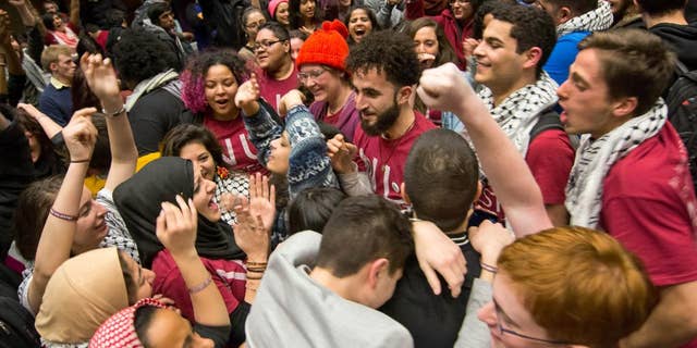 In this photo provided by the The Daily Northwestern, Northwestern University students celebrate after the Associated Student Government Senate passed a Northwestern Divest-sponsored resolution in Evanston, Ill. just before 1:30 a.m. on Thursday, Feb. 19, 2015. The resolution asks the university to divest from six corporations the resolution’s sponsors say violate Palestinians' human rights. (AP Photo/The Daily Northwestern, Nathan Richards)