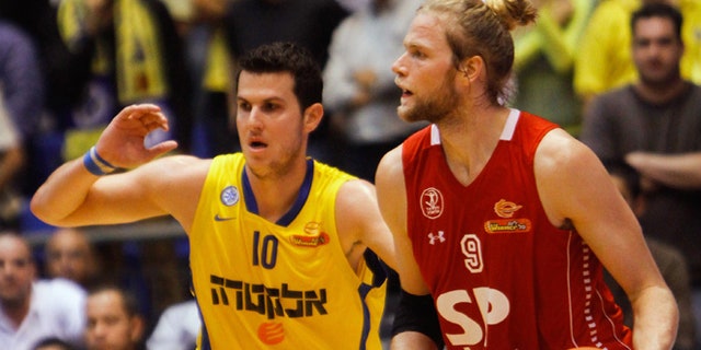 Dec. 2, 2012: In this photo, Maccabi Tel Aviv basketball club captain Guy Pnini, left, and Hapoel Tel Aviv player Jonathan Skjöldebrand, play during a match between the clubs in Tel Aviv.