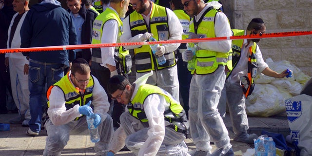 Nov. 18, 2014: Paramedics wipe the blood from pavement outside a synagogue after a shooting attack in Jerusalem. (AP)