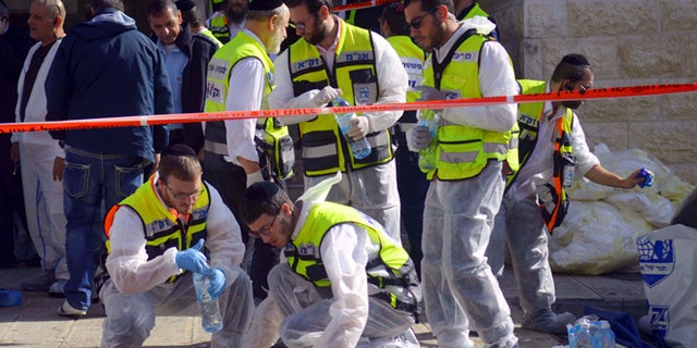 Nov. 18, 2014: Paramedics wipe the blood from pavement outside a synagogue after a shooting attack in Jerusalem. (AP)