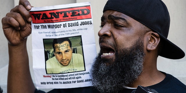 Isaac Gardner of the Justice for David Jones Coalition holds a picture of Pownall after his indictment was announced Tuesday.