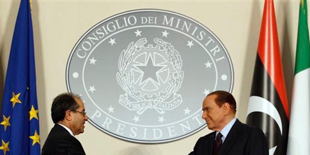 August 25: Italian premier Silvio Berlusconi, right, shakes hands with Mahmoud Jibril, deputy chairman of the Libyan National Transitional Council, during their meeting at the prefecture building in Milan, Italy.