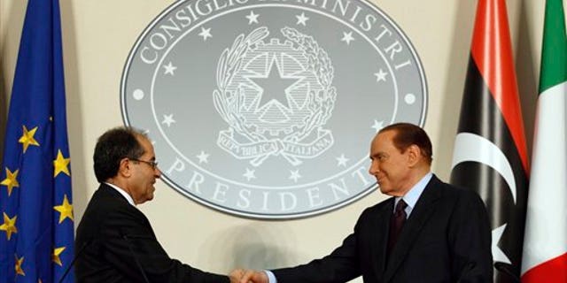 August 25: Italian premier Silvio Berlusconi, right, shakes hands with Mahmoud Jibril, deputy chairman of the Libyan National Transitional Council, during their meeting at the prefecture building in Milan, Italy.