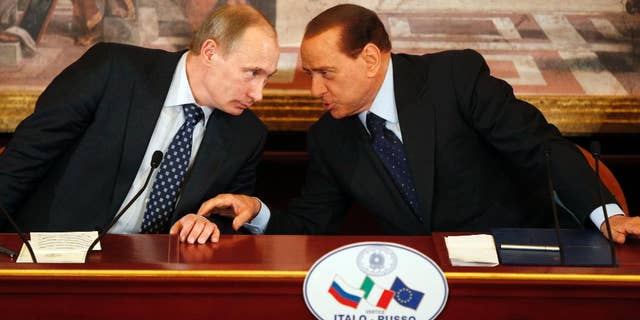 In this April 26, 2010, file photo, then Italian Premier Silvio Berlusconi, right, and Russian President Vladimir Putin talk during a press conference at Villa Gernetto, in Gerno, near Milan, Italy. The Kremlin is denying that President Vladimir Putin offered to make Silvio Berlusconi his economy minister, though he did extend "metaphorical support" to Italy's embattled ex-premier. (AP Photo/Luca Bruno, File)