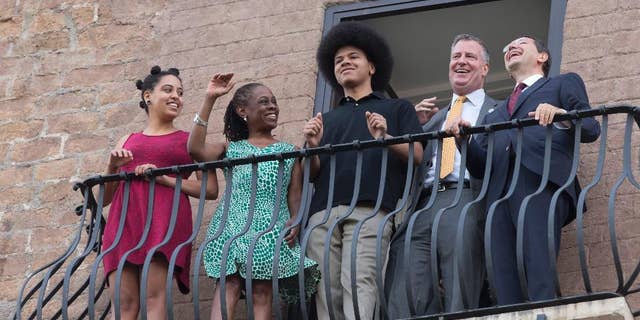 New York City Mayor Bill de Blasio, second from right, shares a laugh with Rome Mayor Ignazio Marino, right, as he is accompanied by his family, from left; daughter Chiara, wife Chirlane McCray, and son Dante, as the look out from a balcony of Rome's Campidoglio, Capitol Hill, overlooking the Roman Forum and Colosseum, Sunday, July 20, 2014. De Blasio and his family are in Italy for a family vacation. (AP Photo/Alessandra Tarantino)
