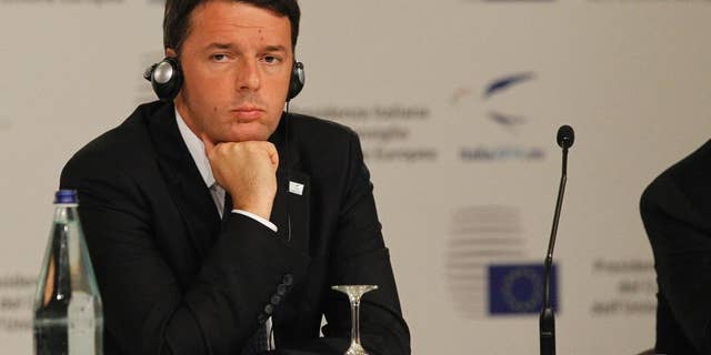 Italian Premier Matteo Renzi listens during a press conference at the EU jobs summit in Milan, Italy, Wednesday, Oct. 8, 2014. European leaders have debated ways to find work for the continent's 25 million unemployed at a summit Wednesday, as popular frustration grows at authorities' failure to return the continent's economy to health. Several thousand union activists protested outside the venue, demanding a stop to government spending austerity policies and calling for reforms to encourage investment. (AP Photo/Felice Calabro')