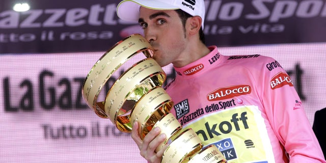 Spain's Alberto Contador kisses the trophy after winning the Giro d'Italia, Tour of Italy cycling race, in Milan, Italy, Sunday, May 31, 2015. Alberto Contador clinched his second Giro d'Italia title on Sunday, remaining on course to become the first cyclist since 1998 to win the Italian classic and the Tour de France in the same year. (AP Photo/Antonio Calanni)