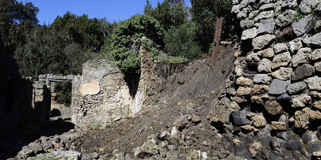 Bricks and rocks are seen on the ground after a section of wall around an ancient shop collapsed in Pompeii as a consequence of a rainstorm, Monday, March 3, 2014.