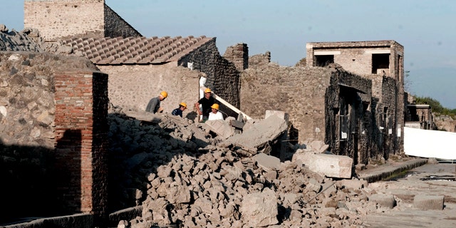 Workers stand among debris in the ancient Roman city of Pompeii, Italy, Saturday, Nov. 6, 2010. Officials say that a house in the ancient Roman city of Pompeii once used by gladiators to train before combat has collapsed. The site was closed at the time and nobody was injured. The office of Pompeii's archaeological superintendent said the collapse occurred Saturday at around 6 a.m. (0500 GMT). Attendants opening the site saw the collapse about an hour later.