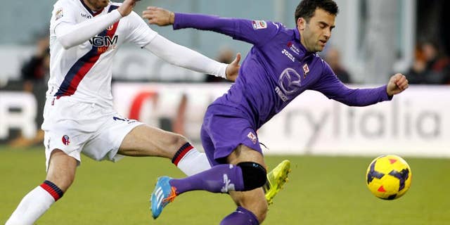 In this Dec. 15, 2013, file photo, Fiorentina's Giuseppe Rossi dribbles past Bologna's Cesare Natali during a Serie A soccer match at Artemio Franchi stadium in Florence, Italy. Rossi and Antonio Cassano were called up for World Cup fitness tests Friday, April 11, 2014, by Italy coach Cesare Prandelli. Rossi was Serie A's top scorer until he re-injured his problematic right knee in January and has only recently begun training again. (AP Photo/Fabrizio Giovannozzi, File)