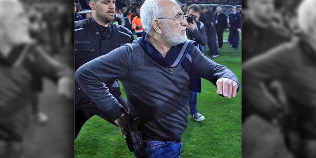 PAOK owner, businessman Ivan Savvidis invades into the pitch during a Greek League soccer match between PAOK and AEK Athens in the northern Greek city of Thessaloniki, Sunday, March 11, 2018. Savvidis came on the field twice and was accompanied by bodyguards. On the second occasion, without the overcoat he was wearing before, Savvidis appeared to be carrying a pistol which was in its holder. Savvidis made no move to use the weapon at any time. (InTime Sports via AP)