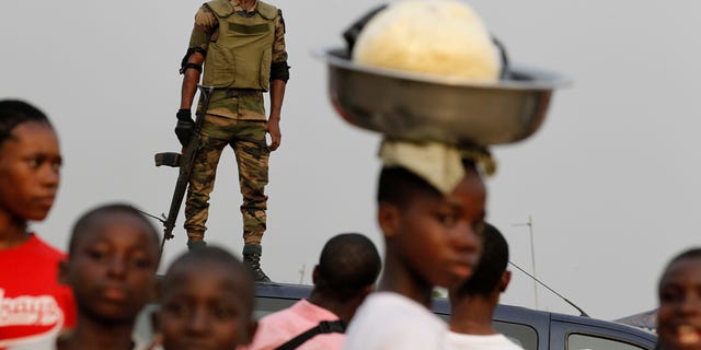 Jan. 5, 2011: A member of the security forces stands guard as people gather for a rally by youth leader Charles Ble Goude in support of Laurent Gbagbo, who recently named Goude to his cabinet, in the Koumassi neighborhood of Abidjan, Ivory Coast. While the United Nations and other world powers recognize rival Alassane Ouattara as the winner of November presidential elections, Gbagbo has refused to step down for more than a month after the presidential runoff vote. The 15-nation regional bloc ECOWAS (The Economic Community Of West African States) has threatened to remove the incumbent leader if ongoing negotiations fail.