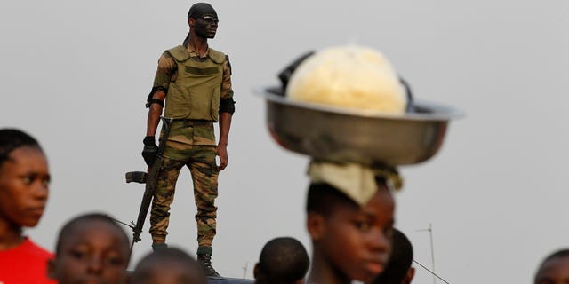 Jan. 5, 2011: A member of the security forces stands guard as people gather for a rally by youth leader Charles Ble Goude in support of Laurent Gbagbo, who recently named Goude to his cabinet, in the Koumassi neighborhood of Abidjan, Ivory Coast. While the United Nations and other world powers recognize rival Alassane Ouattara as the winner of November presidential elections, Gbagbo has refused to step down for more than a month after the presidential runoff vote. The 15-nation regional bloc ECOWAS (The Economic Community Of West African States) has threatened to remove the incumbent leader if ongoing negotiations fail.