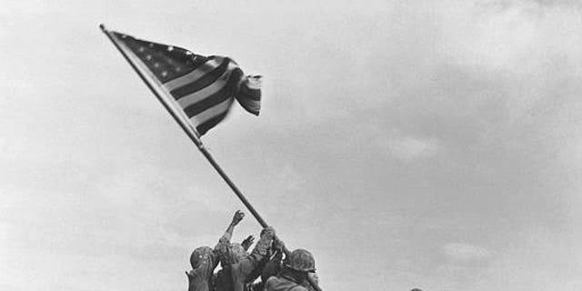 U.S. Marines of the 28th Regiment, 5th Division, raise the American flag atop Mt. Suribachi, Iwo Jima, on Feb. 23, 1945.