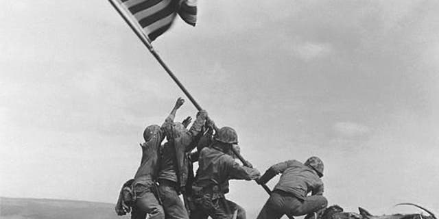 U.S. Marines of the 28th Regiment, 5th Division, raise the American flag atop Mt. Suribachi, Iwo Jima, on Feb. 23, 1945. Strategically located only 660 miles from Tokyo, the Pacific island became the site of one of the bloodiest, most famous battles of World War II against Japan.  (AP Photo/Joe Rosenthal)