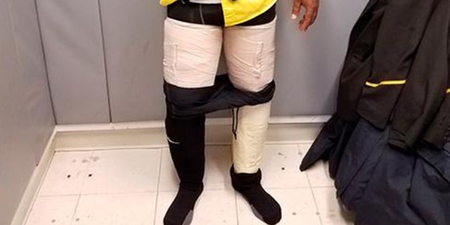 Customs officers discovered four packages containing white powder taped to an airline crew member's legs.