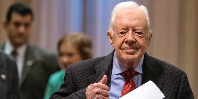 El expresidente de Estados Unidos Jimmy Carter llega a una conferencia de prensa acompañado de su esposa Rosalynn en Atlanta el jueves 20 de agosto de 2015.  (Foto AP/Ron Harris)