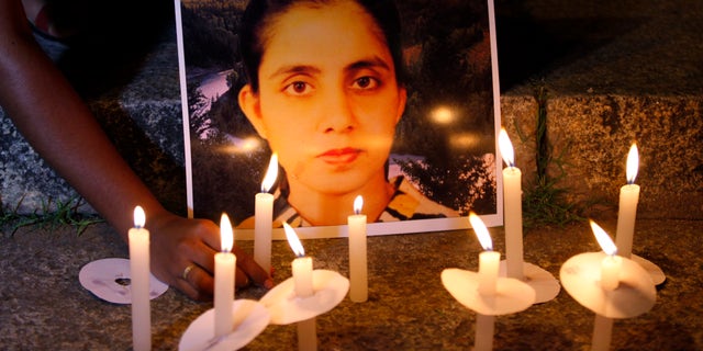 Dec. 13, 2012: A student of a nursing college places a candle in front of a picture depicting nurse Jacintha Saldanha, during a candle-lit vigil organized by a local politician in Bangalore, India.