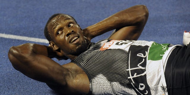 July 1, 2012: World-record holder Usain Bolt looks at the crowd while getting his right hamstring stretched out after loosing to fellow country man Yohan Blake in the 200m final at Jamaica's Olympic trials in Kingston, Jamaica.