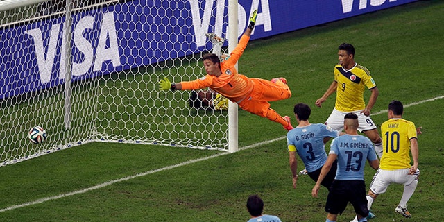 Colombia's James Rodriguez, right, scores his side's second goal past Uruguay's goalkeeper Fernando Muslera during the World Cup round of 16 soccer match between Colombia and Uruguay at the Maracana Stadium in Rio de Janeiro, Brazil, Saturday, June 28, 2014. (AP Photo/Themba Hadebe)