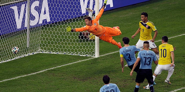 Colombia's James Rodriguez, right, scores his side's second goal past Uruguay's goalkeeper Fernando Muslera during the World Cup round of 16 soccer match between Colombia and Uruguay at the Maracana Stadium in Rio de Janeiro, Brazil, Saturday, June 28, 2014. (AP Photo/Themba Hadebe)