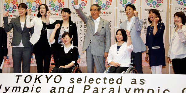 May 24, 2012: Tokyo Gov. Shintaro Ishihara, center, chairman of Tokyo 2020 Council, shows his spirit with Japanese Olympians and Paralympians during a press conference in Tokyo.