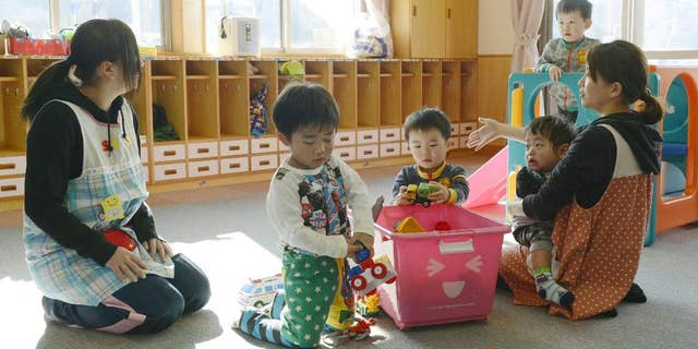 Toddlers play at a nursery school in Tamura, Fukushima Prefecture, northeastern Japan, Tuesday, April 1, 2014 after authorities allowed residents to return to live in their homes within a tiny part of a 20-kilometer (12-mile) evacuation zone around the Fukushima plant for the first time since Japan's nuclear disaster three years ago. The decision, which took effect Tuesday, applies to 357 people in 117 households from a corner of Tamura city after the government determined that radiation levels are low enough for habitation. (AP Photo/Kyodo News) JAPAN OUT, MANDATORY CREDIT