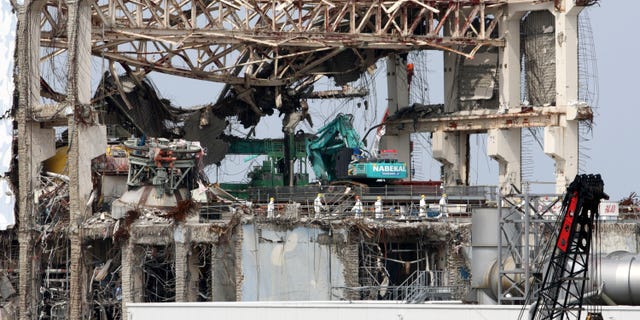May 26, 2012: Goshi Hosono, Japan's environment and nuclear minister, third from left, wearing a red helmet, along with members of the media, walks on the No. 4 reactor building at Tokyo Electric Power Co.'s (TEPCO) Fukushima Dai-ichi nuclear power plant in Okuma, Fukushima prefecture, Japan.