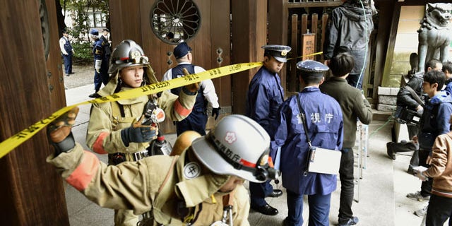 Nov. 23, 2015: Firefighters and police officers inspect around the south gate of Yasukuni shrine in Tokyo after an explosion was reported. No one was injured. (Shigeyuki Inakuma/Kyodo News via AP)
