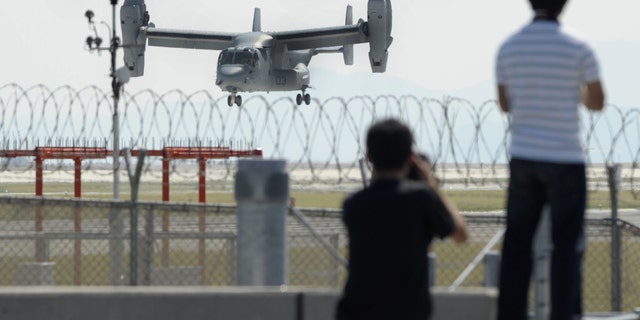 Photographers stand as an MV-22 Osprey aircraft takes off from Iwakuni Air Base, Yamaguchi prefecture, southern Japan, Friday, Sept. 21, 2012. The U.S. Marines conducted their first test flights of the MV-22 Osprey aircraft in Japan after months of protests there over safety concerns. (AP Photo/Kyodo News) JAPAN OUT, MANDATORY CREDIT, NO LICENSING IN CHINA, HONG KONG, JAPAN, SOUTH KOREA AND FRANCE