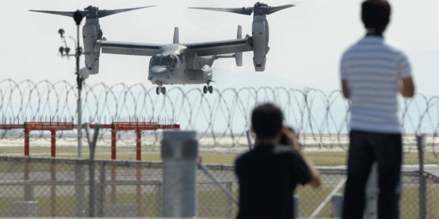 Photographers stand as an MV-22 Osprey aircraft takes off from Iwakuni Air Base, Yamaguchi prefecture, southern Japan, Friday, Sept. 21, 2012. The U.S. Marines conducted their first test flights of the MV-22 Osprey aircraft in Japan after months of protests there over safety concerns. (AP Photo/Kyodo News) JAPAN OUT, MANDATORY CREDIT, NO LICENSING IN CHINA, HONG KONG, JAPAN, SOUTH KOREA AND FRANCE