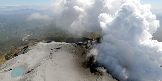 September 30, 2014: An aerial view shows volcanic smoke and fumes rising from the craters of Mount Ontake, central Japan. (AP Photo/Kyodo News)